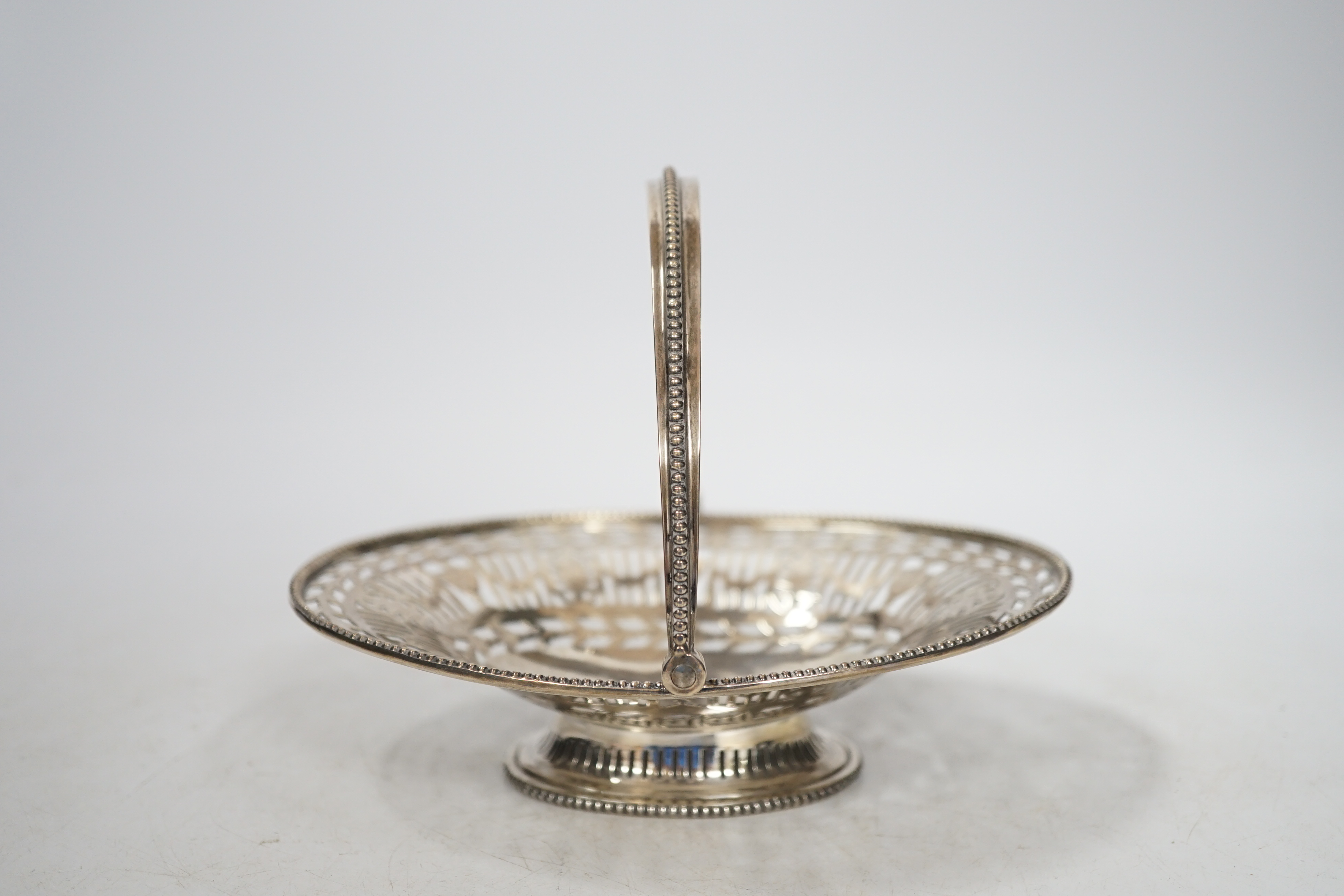 A George V pierced silver oval sweetmeat dish, with swing handle and fretwork decoration, Goldsmiths & Silversmiths Co., London 1912, 16cm, 174 grams